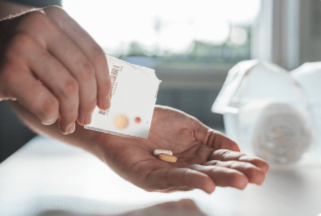 Hand pouring pills from a torn-open daily dose sachet